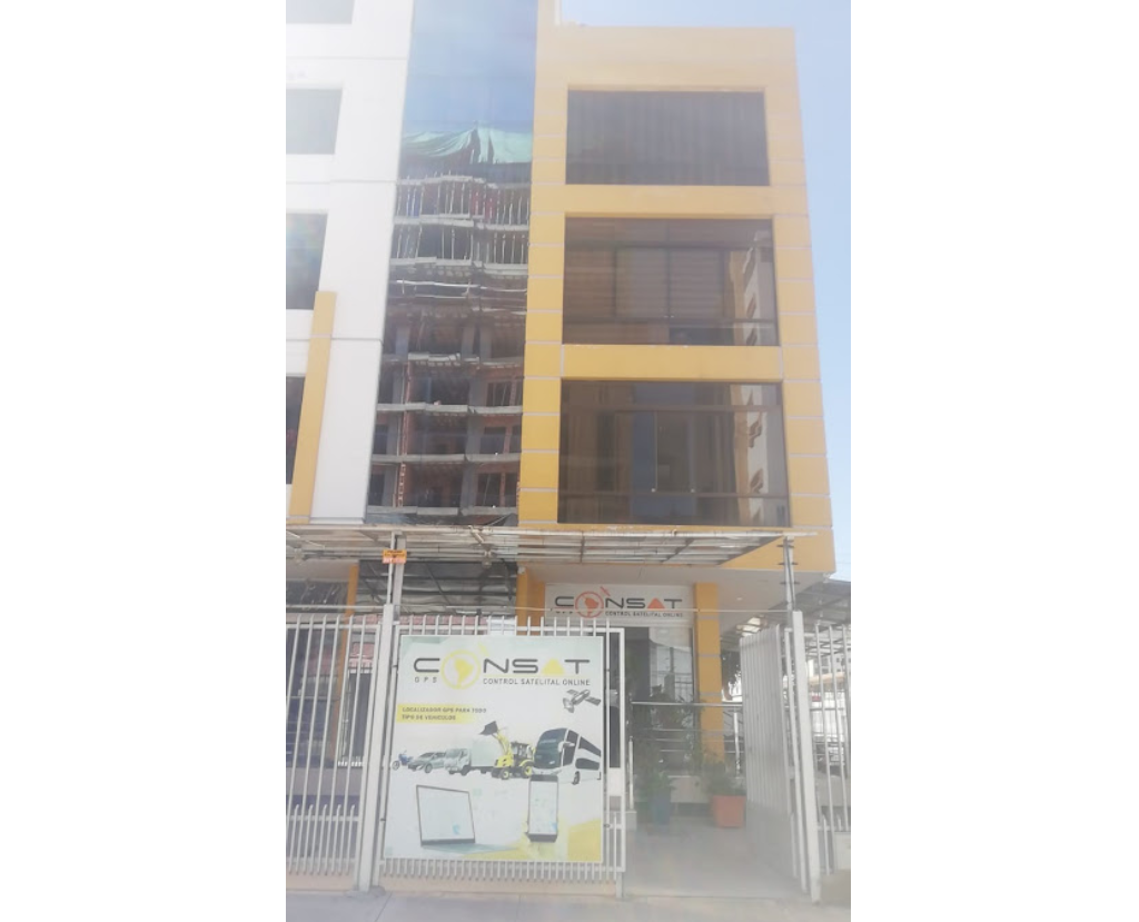 Entrada de la sucursal en Cochabamba, Bolivia, con un cartel visible y árboles alrededor